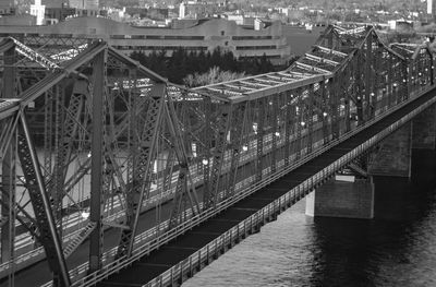 Bridge over river in city against sky