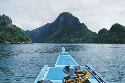 Cropped image of boat in river against mountains