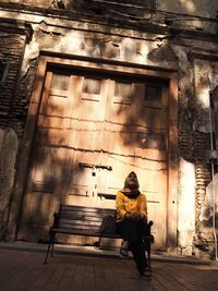 Full length of woman sitting outdoors