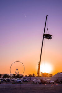 Low angle view of electricity pylon against sky during sunset