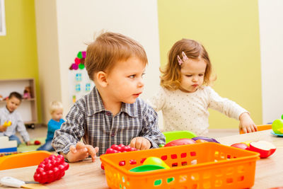 Boy and girl playing with toy at kindergarten