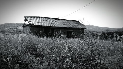 House on field against clear sky