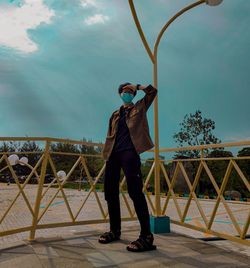 Full length of man standing by railing against sky