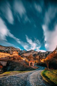 Road amidst landscape against sky at night