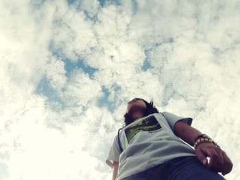 Silhouette of woman standing against cloudy sky