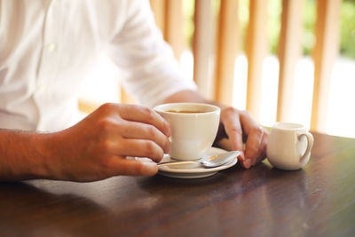 Midsection of coffee cup on table