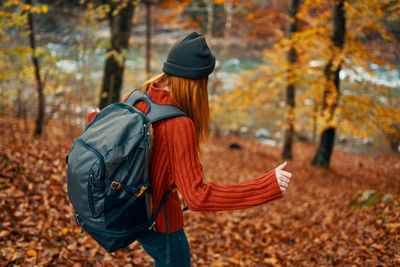 Midsection of woman with umbrella during autumn