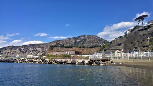 Scenic view of lake and mountains against blue sky