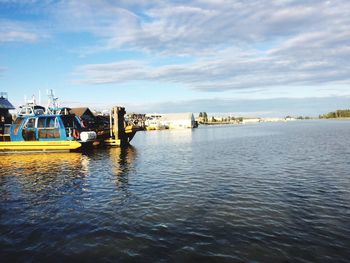 Boats in sea against cloudy sky