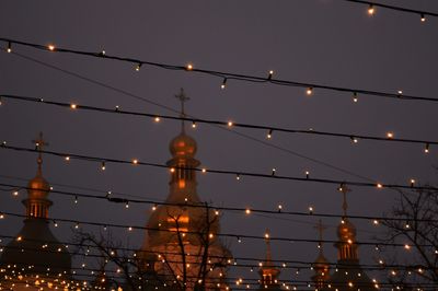 Low angle view of illuminated suspension bridge at night
