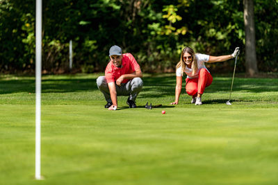 Young couple on a golf course, reading green