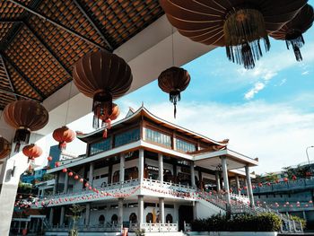 Low angle view of lanterns hanging from building against sky