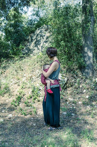 Woman standing on rock in forest