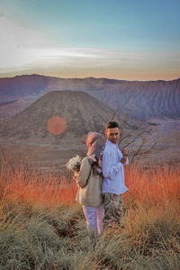 Full length of a man standing on field against sky