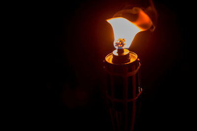 Close-up of lit oil lamp in darkroom