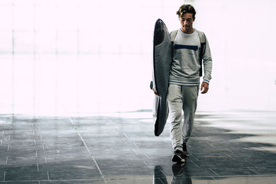 Full length of young man standing against blurred background