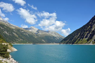 Scenic view of lake by mountains against sky