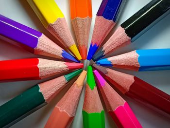 High angle view of multi colored pencils on white background