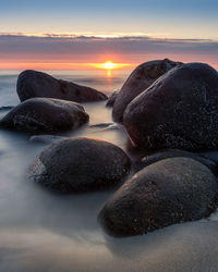 Scenic view of sea against sky during sunset with beach stones