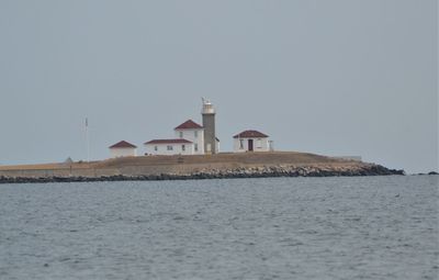Building by sea against clear sky