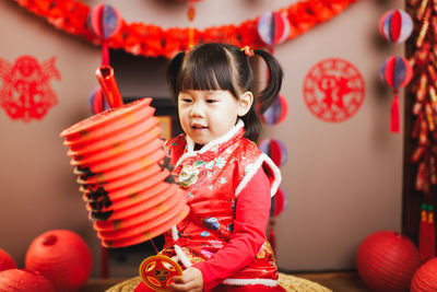 Girl holding lantern sitting at home