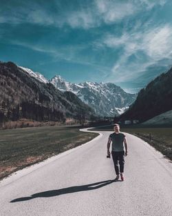 Full length of man walking on road against mountains