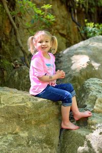 Portrait of smiling girl standing on rock