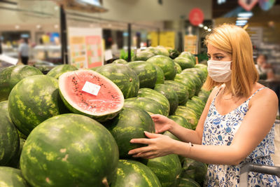 Young woman with vegetables for sale in market