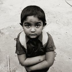 Portrait of boy with arms crossed standing on road