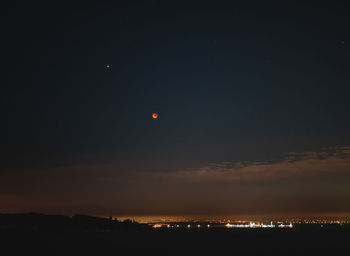 Silhouette landscape against sky at night