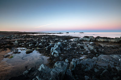 Rocky coastline and seascape against sky