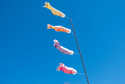 Low angle view of fish against blue sky