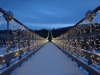 Illuminated bridge against sky at night