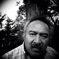 Portrait of mature man against tree at park