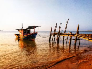 Fishing boat in sea against clear sky