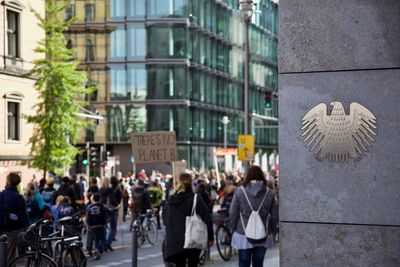 People on street against buildings in city