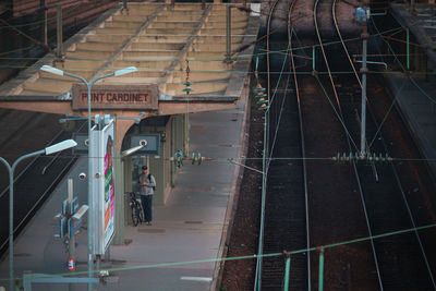 People on railroad tracks amidst buildings in city