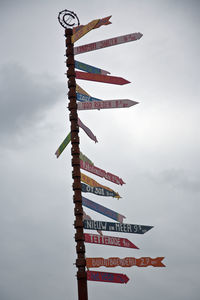 Low angle view of various information signs against sky