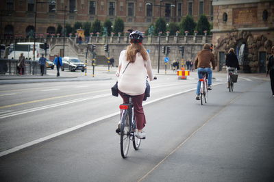 Rear view of friends cycling on road