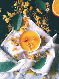 High angle view of cup of juice and flowers on table