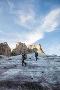 Two mountain climbers traverse a glacier below mount asgard.