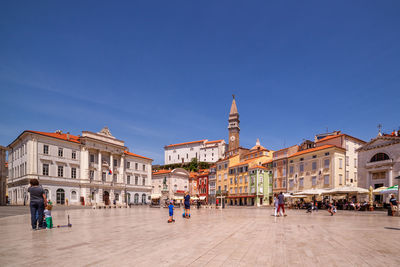 Tourists in front of building against clear sky