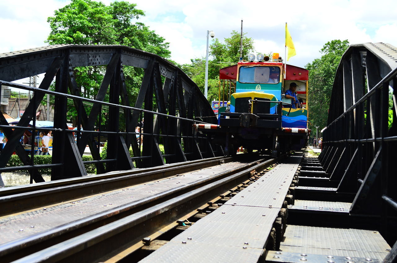 TRAIN IN RAILROAD STATION AGAINST SKY