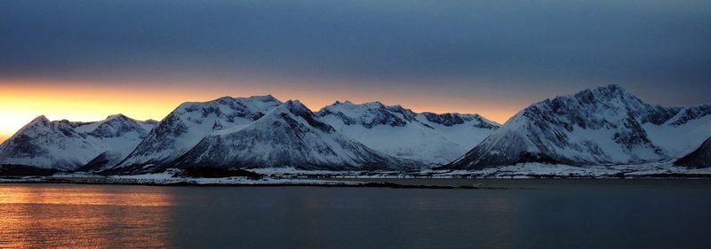 Scenic view of snowcapped mountains against sky during sunset