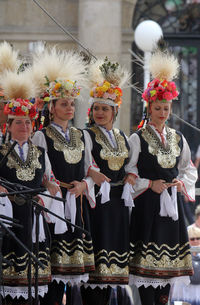 Smiling traditional dancers standing on stage