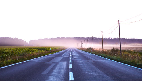 Road passing through landscape against clear sky