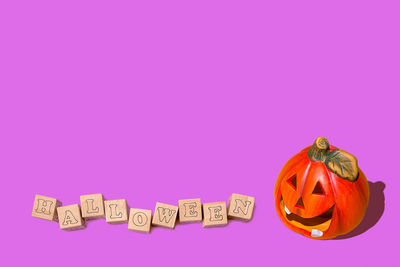 Close-up of pumpkin on table against gray background