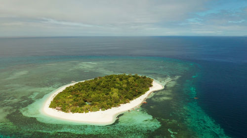 Beautiful beach on tropical island surrounded by coral reef, top view. mantigue island. 