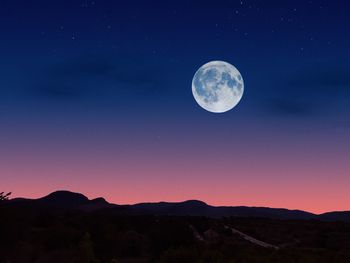 Scenic view of mountains against moon at night