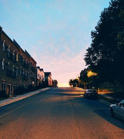 Cars on road against sky during sunset